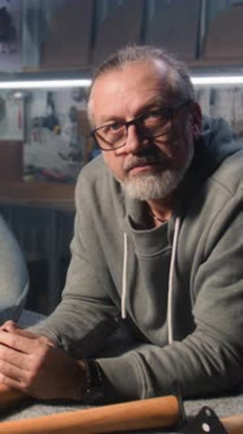 Professional Male Carpenter Stands Near Chair and Looks at Camera