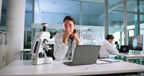 Stressed Scientist Rubbing Temples in Lab