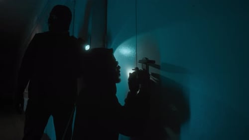 Robber Picking Lock, His Crime Partner Shining Flashlight at Door