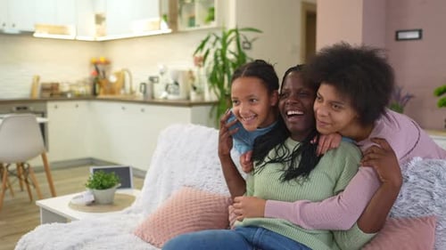 Family Hugs on Couch Laughing in Living Room