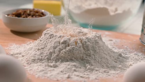 Egg Yolk Falling into Flour Preparing Dough