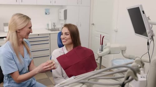 Dentist Explains Dental Care to Smiling Patient