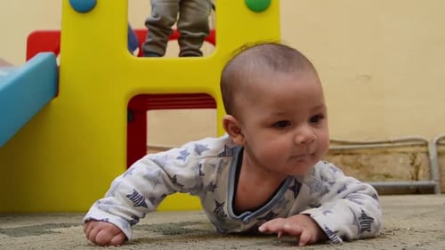 un joli petit garçon de trois mois s'amuse pendant que son frère aîné joue