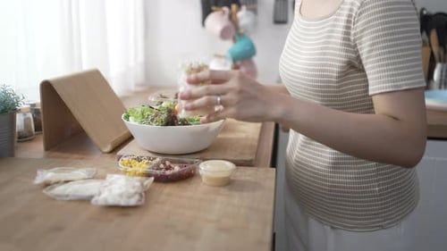 Woman Preparing Healthy Salad in Bright Kitchen