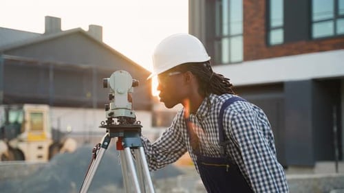 Construction Worker Using Theodolite at Golden Hour
