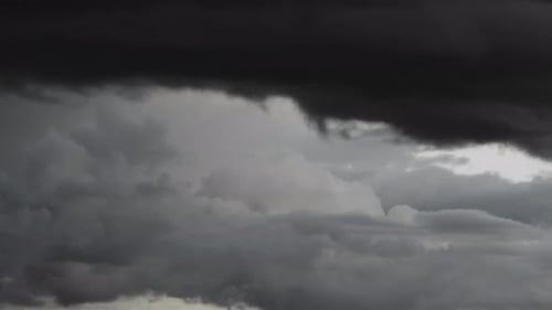 Time lapse of rain clouds rolling in on blue sky.