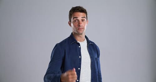 Mann, Daumen runter und negativ ins Gesicht im Studio für Kritik, Feedback und Uneinigkeit, Abstimmung von Gray