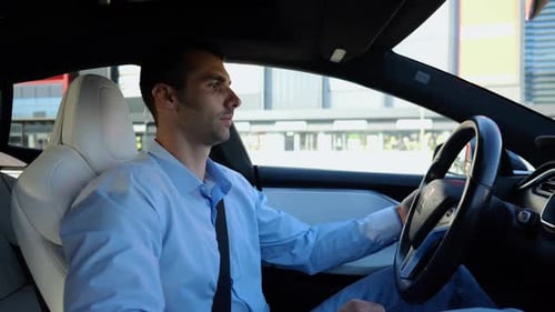 Male Businessperson Experience to Ride an Autonomous Self Driving Electric Car at Urban Road