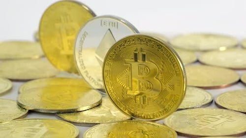 Bitcoin-Goldmünzen und Silber-Ether dazwischen rotieren auf weißem Hintergrund.