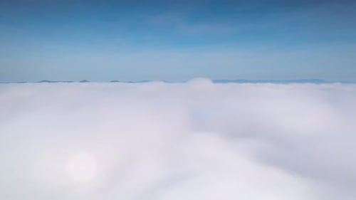 Video from a drone flying through fog and cloud layers. to the top above the cloud.