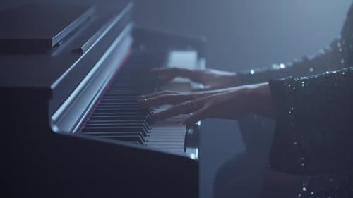 Hands Play Piano Keys Under Spotlights
