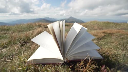 Vídeo abstracto de páginas de libros cerradas por el viento en las montañas