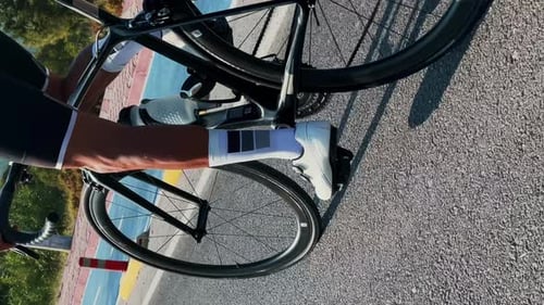 Nahaufnahme muskulöser Männerbeine in Fahrradschuhen beim Fahrradfahren. Vertikales Video