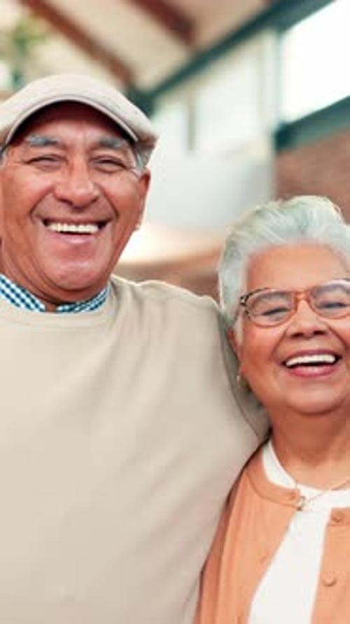 Senior Couple Smiling and Embracing Indoors Happily