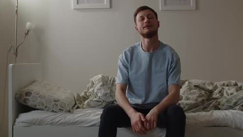 Man Stretching and Yawning in Bed in Morning