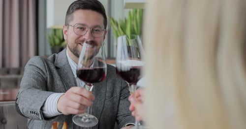Couple Having a Dinner Clinking Glasses of Wine at a Restaurant People Enjoying Their Date Drinking