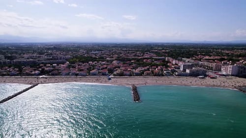 Aerial vflight towards sandy beach of Saint Cyprien during sunny day in France