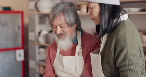 Old couple, love and kiss in pottery workshop or studio molding clay