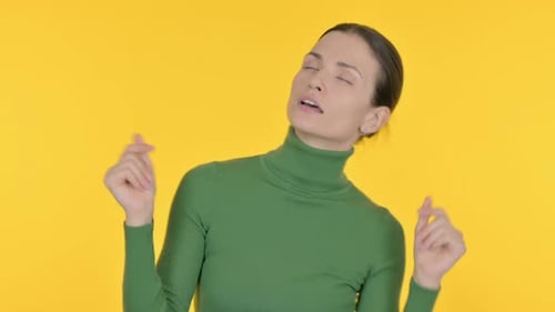 Young Woman Dancing Energetically on Yellow Background