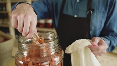A Young Man Shop Assistant Working in a Zero-Waste Store or Shop
