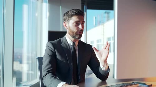 Man in Suit Works at Computer in Bright Office