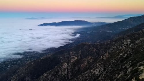 Luftbild von Bergen über niedrigen Wolken in der Morgendämmerung