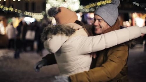 Romantic Couple Embrace at Christmas Market at Night