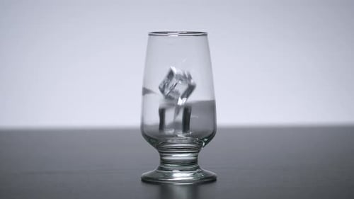 Ice Cubes Dropping into Glass of Water