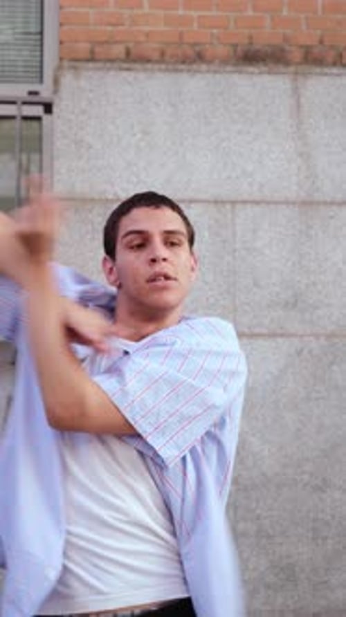 Young energetic man dancing hip hop on the street