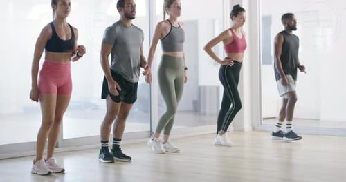 A group of young men and women doing lunges in a gym