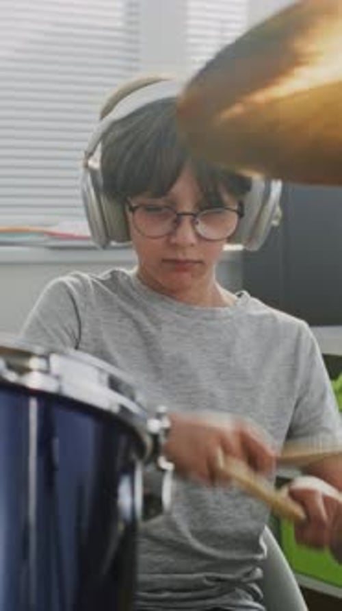 Talented Boy Wearing Headphones Playing Drums in Percussion Class of Elementary School