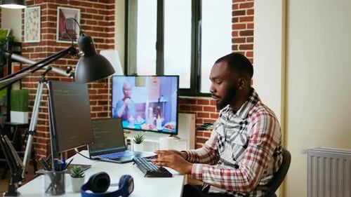 Male Coder Works From Home Typing Code on a Laptop in a Modern Living Room