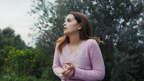Une fille se frotte les mains pour se frissonner à l'extérieur à la campagne