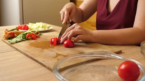 Woman Prepares Fresh Salad by Slicing Tomatoes