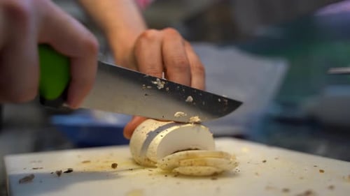 Close up of hand cutting mushrooms in the kitchen 4K