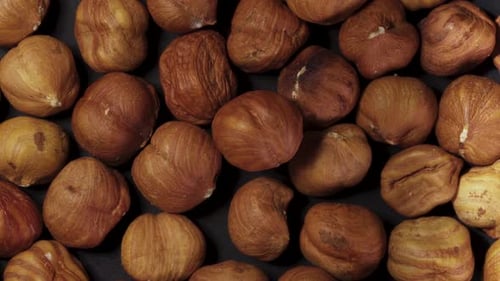 Peeled hazelnuts. Rotates on a black background. a handful of nuts. close-up, top view