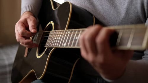 Man Playing Guitar in Home Close Up