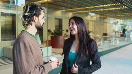 Adult businesswoman in suit talking to office colleague