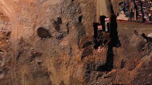 Aerial view of excavator and dump trucks at construction site