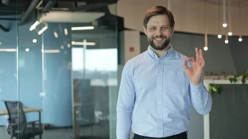 Adult Man Shows OK Hand Gesture in Office