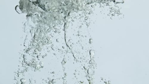 Limes Falling Into Refreshing Water