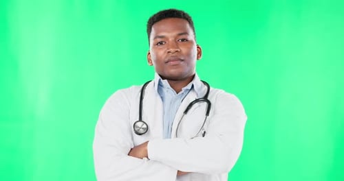 Face, doctor smile and black man with arms crossed on green screen in studio isolated