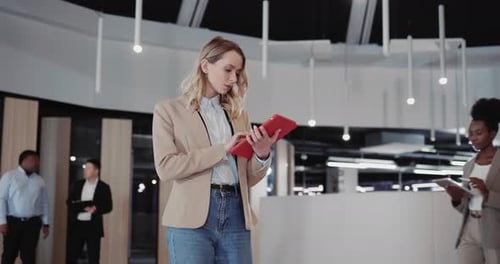 Beautiful Young Caucasian Blonde Woman Boss Leader Heading to Office Cabinet with Tablet Computer