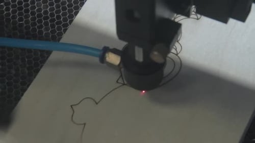 Observe the Laser Cutting Process in a Workshop Highlighting Precision and Creativity