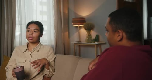 Woman Talking to Man on a Sofa