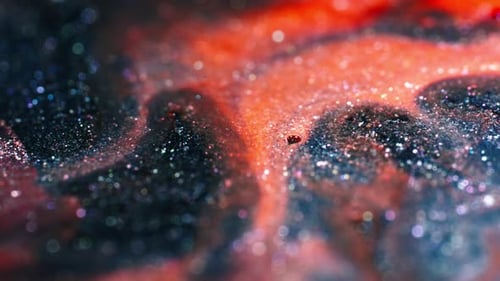Swirling vibrant colors with glitter particles blend in a mesmerizing close-up shot
