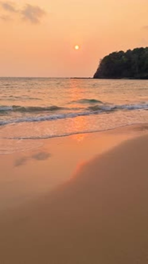 Orange Afterglow Fills the Sky As the Sun Sets Over the Ocean on a Beach