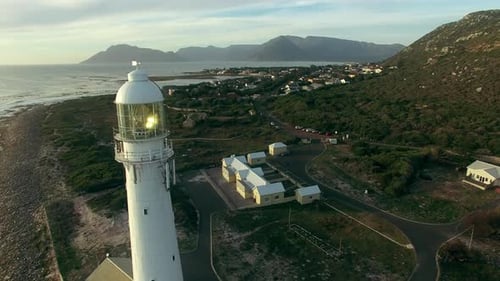 Sunset, drone and ocean with landscape of lighthouse nature, travel beacon and coastal landmark
