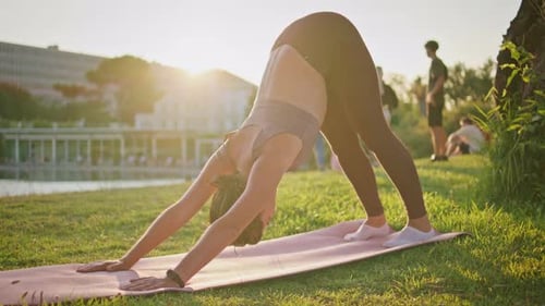Woman Practicing Yoga at Golden Hour Outdoors