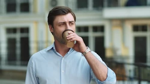 Close Up Serious Businessman Drinking Take Away Coffee At Street. Portrait Of Business Man Waitin...